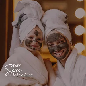 Capa do produto day spa mãe e filha no speciale spa representado por uma mulher e uma menina vestindo roupões brancos e com toalhas bracas enroladas na cabeça. As duas olham para a câmera, sorriem e estão com uma pasta cinza espalhada em seus rostos