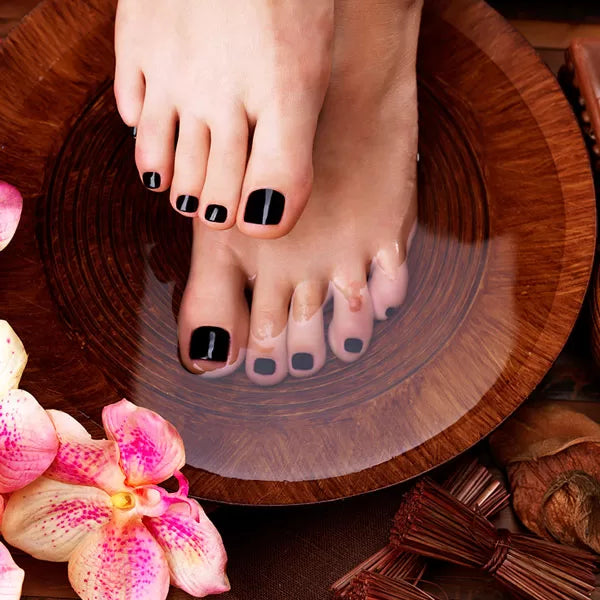 Como parte da experiência do Day Spa essence a foto mostra pés mergulhados na água em uma bacia de madeira