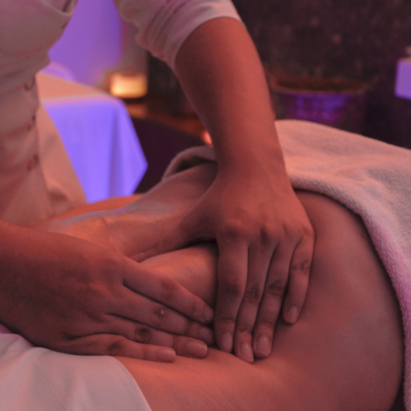 Como parte da experiência a foto mostra a barriga de uma pessoa sendo pressionada por duas mos. A parte de cima e de baixo do corpo da pessoa estão cobertas por toalhas brancas