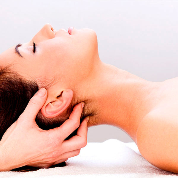 Como parte da experiência do Day Spa erva doce a foto mostra a lateral direita do rosto de uma mulher que está com os olhos fechados. Uma mão segura a cabeça dela e preciona os dedos em sua nuca
