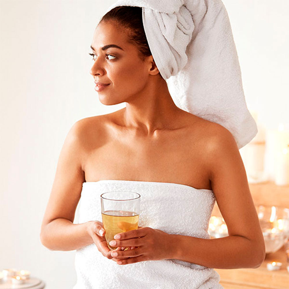 Capa do produto day spa wintergreen no speciale spa representado uma foto de dois pés apoiados na vertical em cima de uma toalha branca. Um par de mão os aperta, com os polegares pressionando no centro de cada pé, abaixo dos dedos. Em volta, há velas acesas